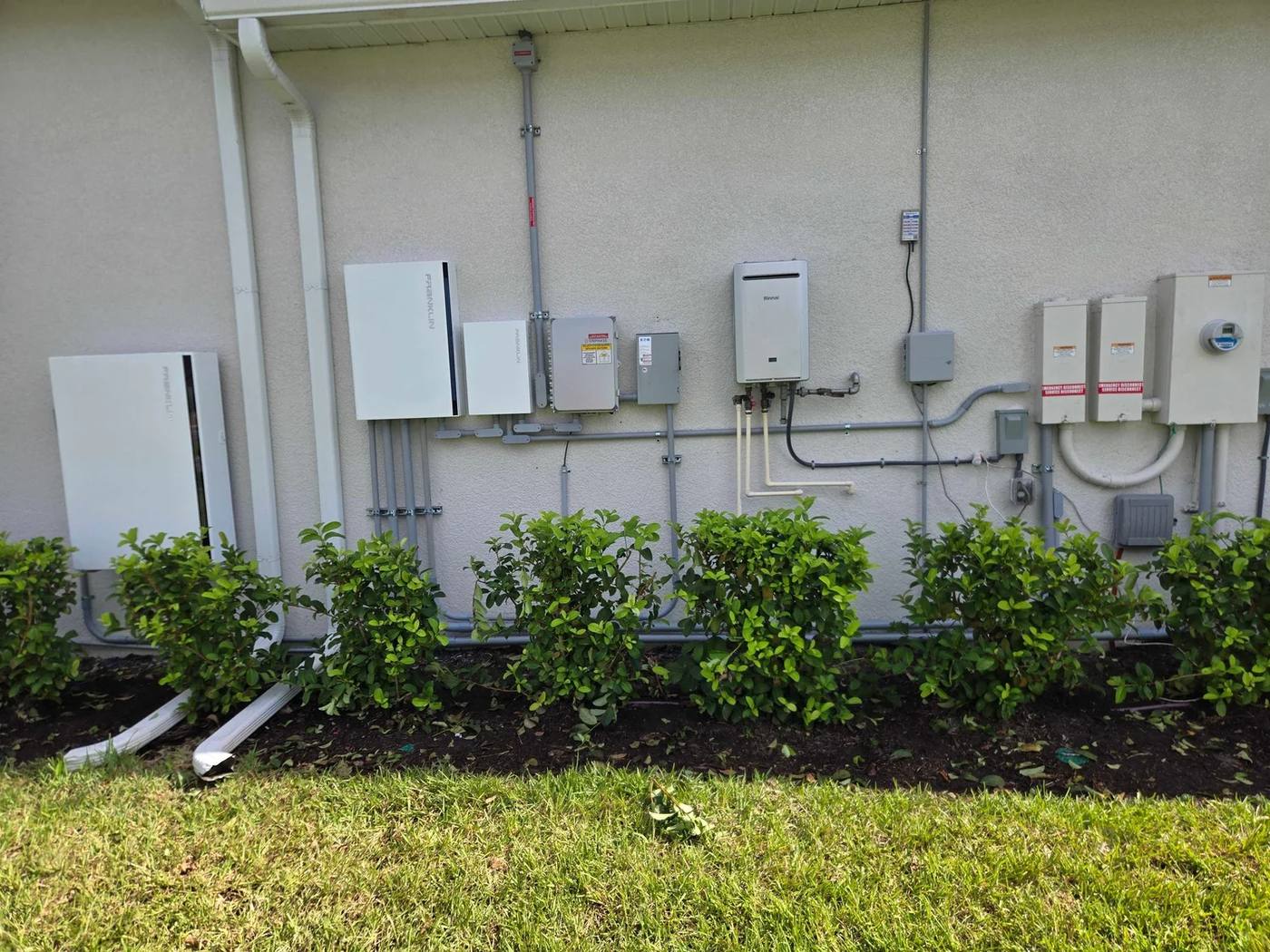 Inverters, batteries and disconnects on the outside wall of a home